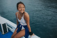 a young woman sitting on the edge of a boat